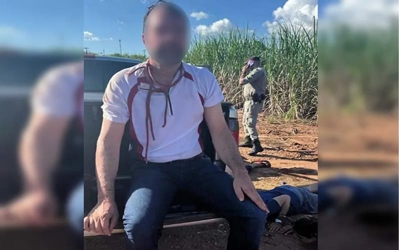 Vítima sentada na tampa da carroceria da caminhonete após o resgate, em Itapaci, Goiás — Foto: Reprodução/Polícia Militar