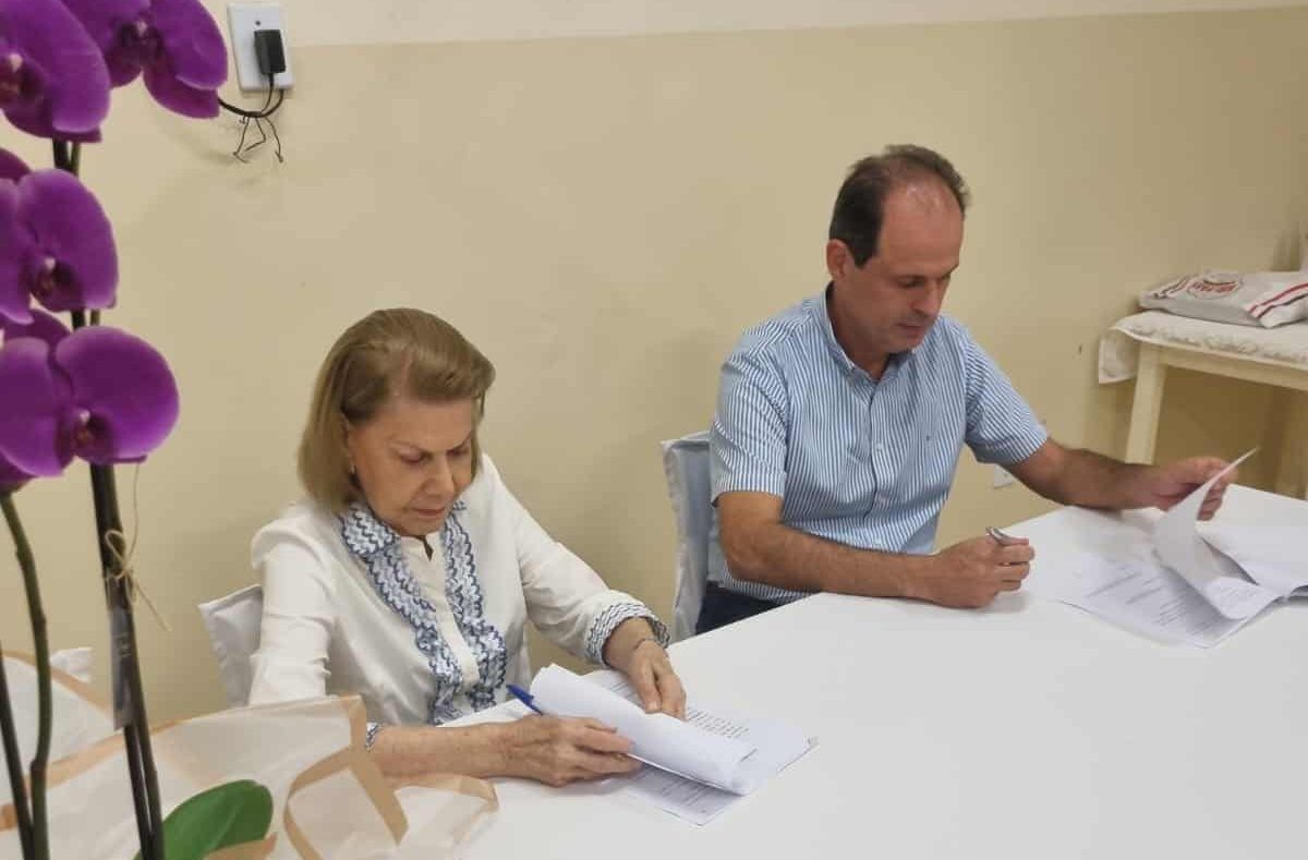 A presidente do centro espírita Amor e Caridade, Nancy Dias de Almeida, e o presidente da Rede de Supermercados, Fernando Farinha Júnior, assinam o contrato de compra e venda do terreno