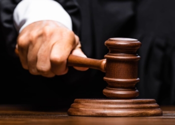 vista do juiz em roupão judicial sentado à mesa